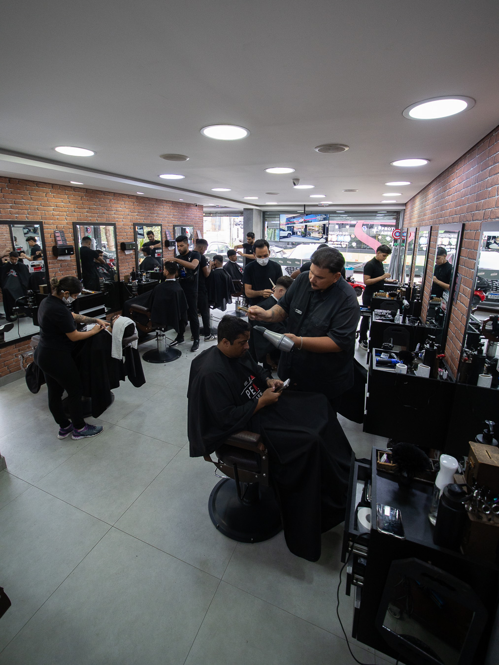 Interior da Barbearia Peniel Butantã — todos os cadeirões em atendimento